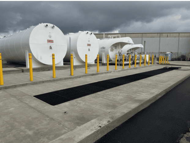 White industrial tanks with yellow safety barriers in Birmingham.