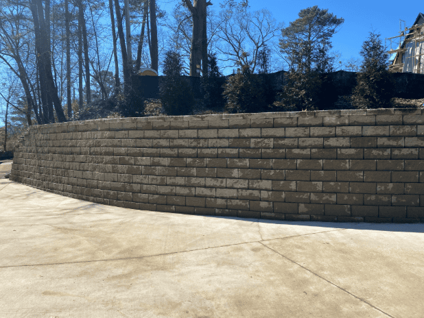 Curved retaining wall in a landscaped area.